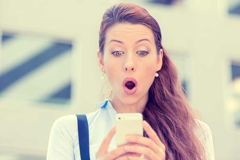 lady surprised looking at a text message on her phone